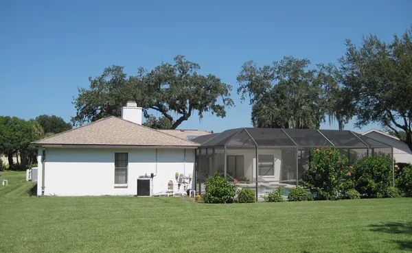 Dark-bronze mansard-style pool cage along a single-story home, Sarasota County, FL