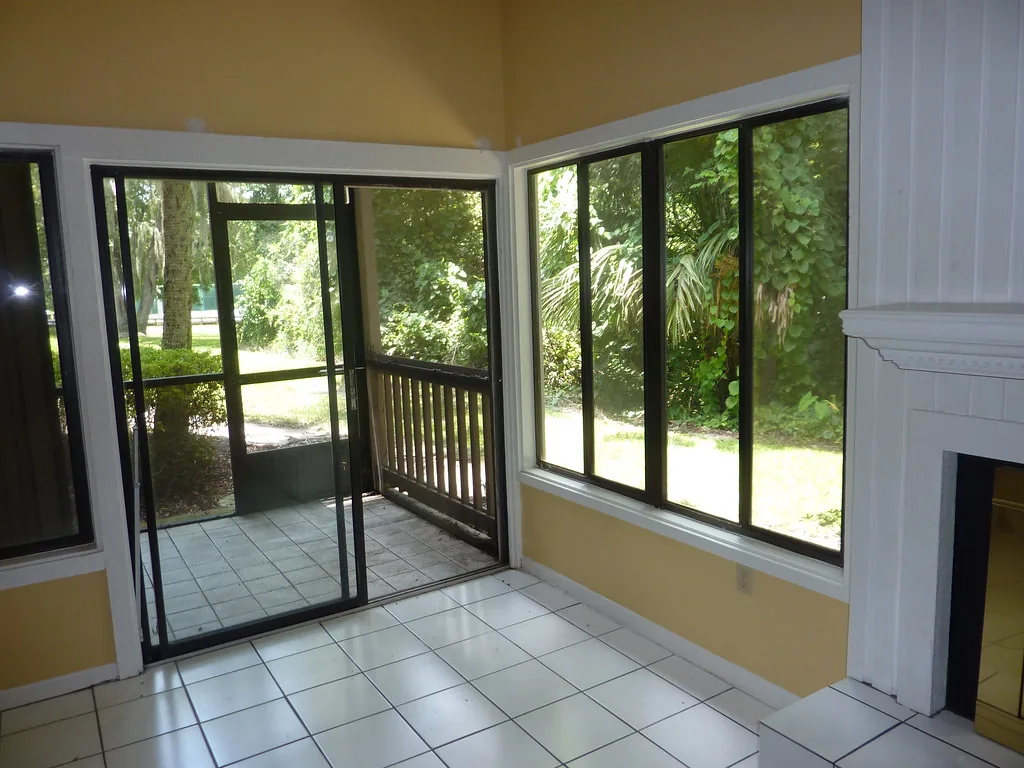 Tiled screen room with a black-framed screen door and screen walls