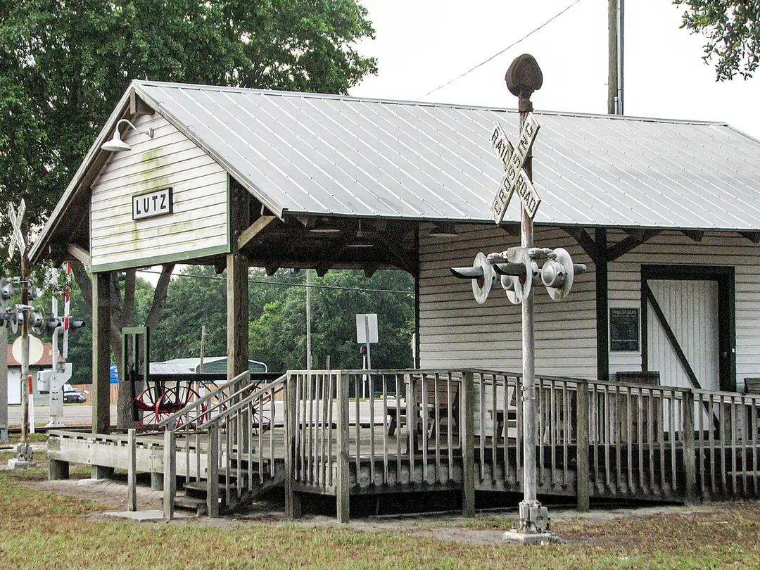The rebuilt white wooden Lutz train depot with a metal roof and railroad crossing signal, Lutz, FL