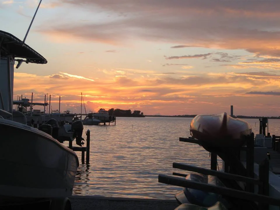 Orange sunset over the water from a boat dock in Ozona, Palm Harbor, FL