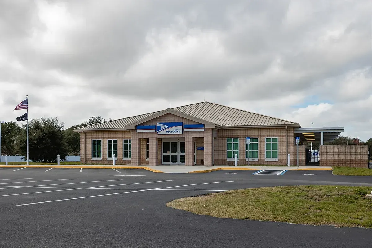 The Parrish post office, a tan brick building with a metal roof, in Parrish, FL