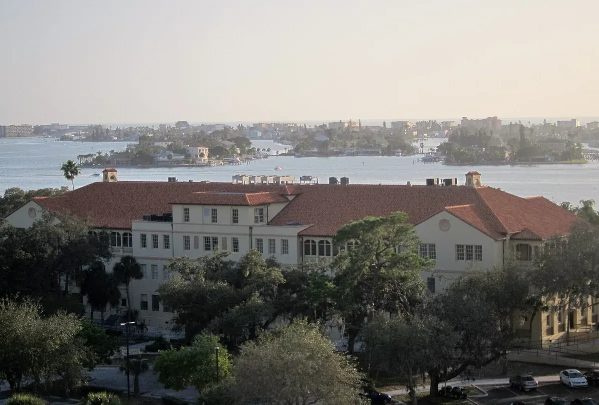 Historic red-roofed building among trees with Pinellas County waterways behind