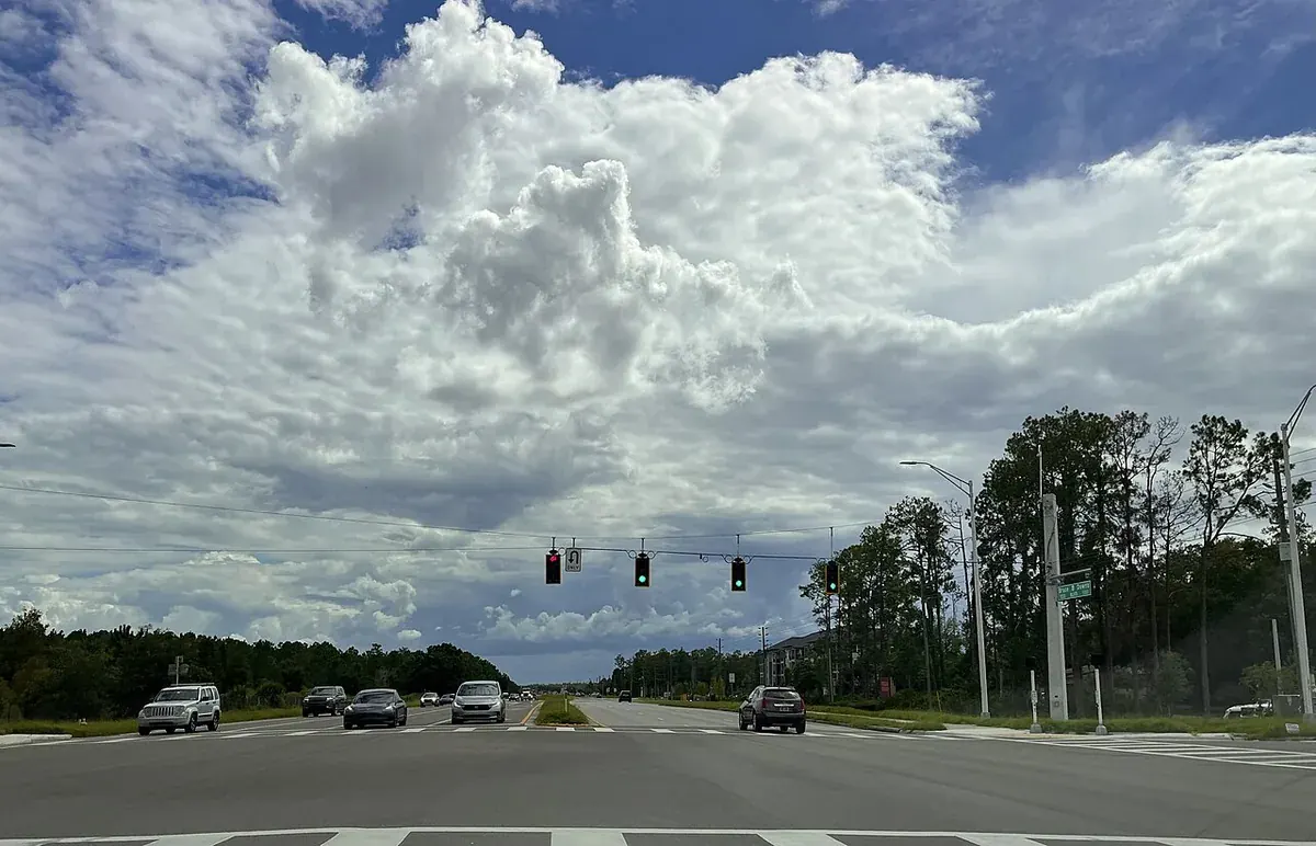 Multi-lane road through Wesley Chapel, Pasco County, FL under tall cumulus clouds